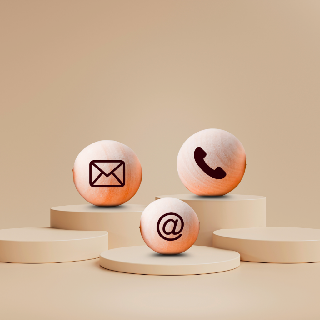 3D minimalist spheres on podiums featuring email envelope, telephone handset, and @ symbol icons representing Chai Media contact options.